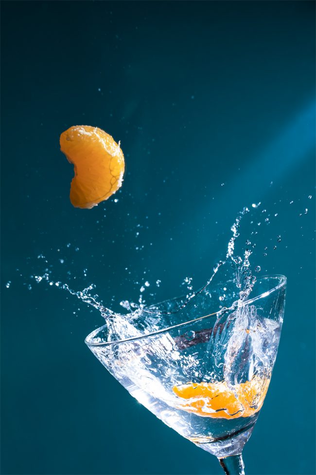 mandarina salpicando en una copa de coctel